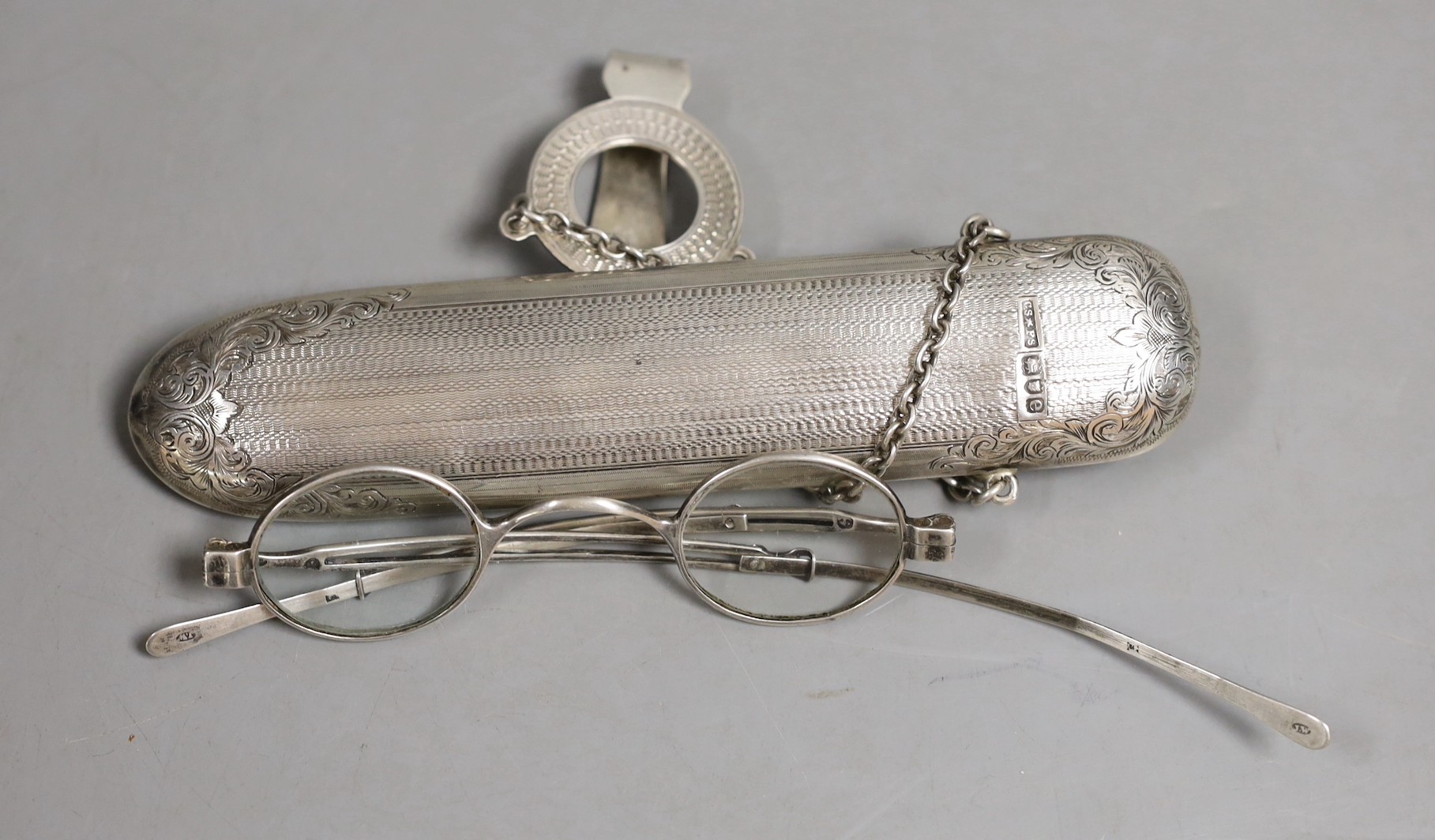 A late Victorian engine turned silver spectacles case, Saunders & Shepherd, London 1900, 17cm containing an earlier pair of Georgian silver spectacles by Joseph Wilmore.